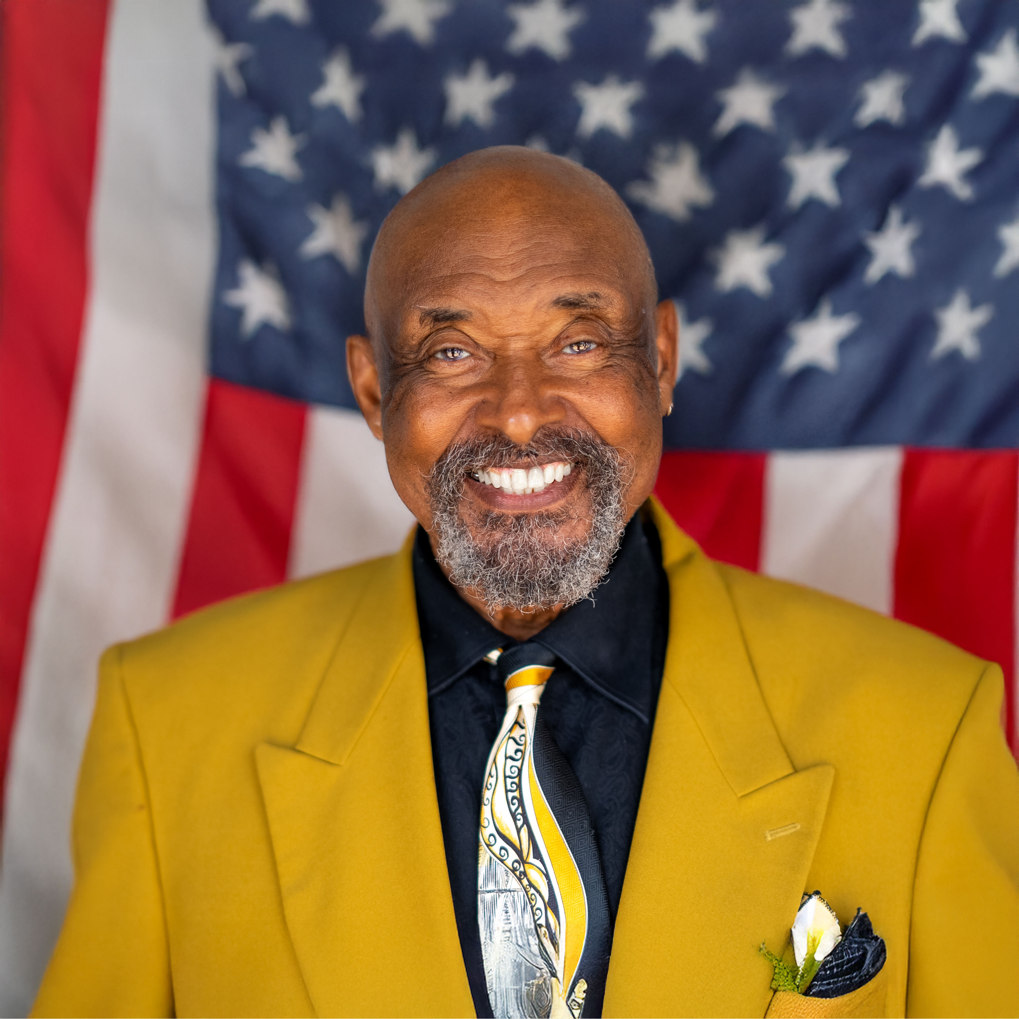 Vernon Yates standing proudly in front of the American flag